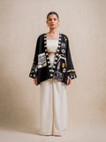 Front view of the Adara Black short kimono worn by a model, featuring hand-printed motifs on a beige background
