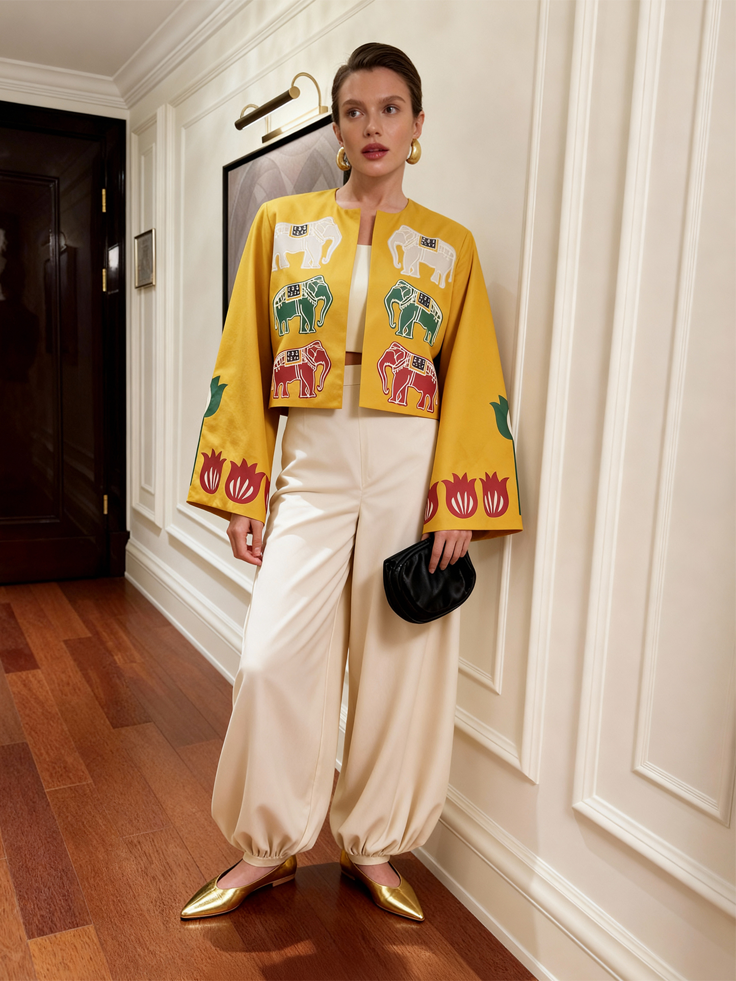 Model wearing the Alam Guman Ochre short jacket with hand-printed elephant motifs, styled indoors