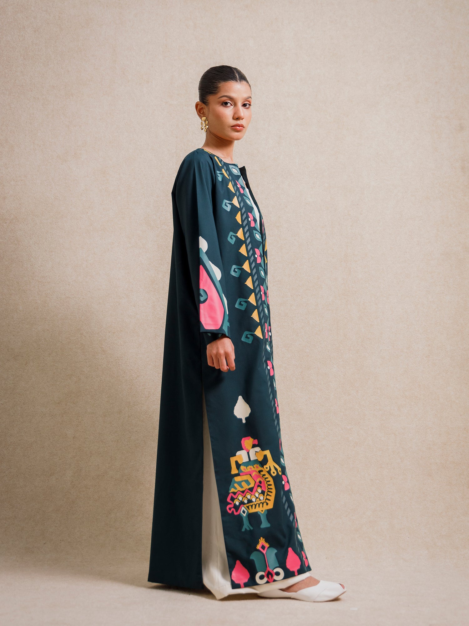 Side view of Jade Fest Green long jacket highlighting its length, drape, and screen-printed motifs