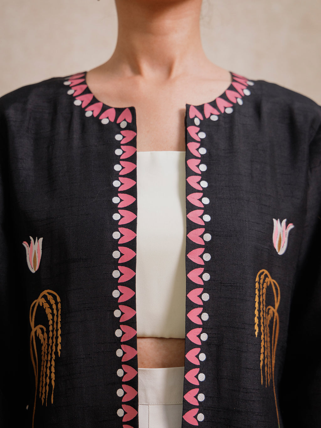 Close-up of the Courtyard Dance black long jacket highlighting the hand-printed neckline border with floral and geometric motifs