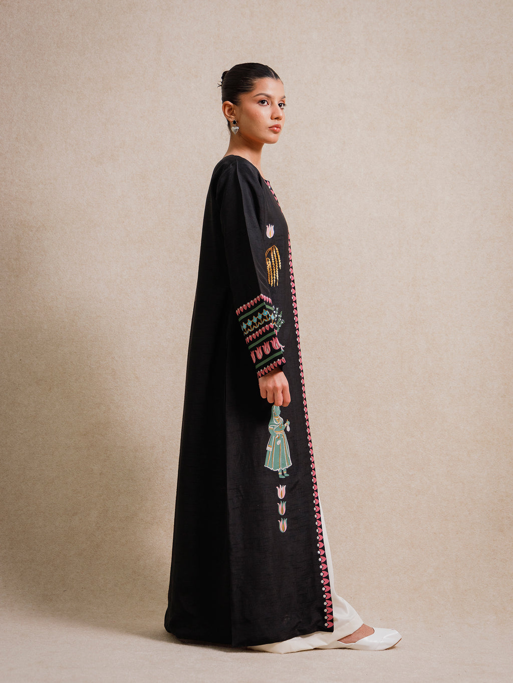 Side view of the Courtyard Dance black long jacket featuring hand-printed figurative motifs and patterned sleeve borders