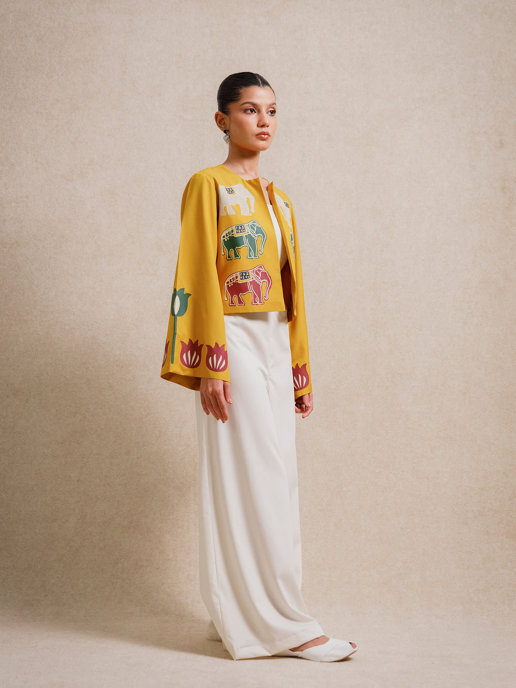 Front angled view of the Alam Guman Ochre short jacket featuring hand-printed elephant motifs on ochre fabric