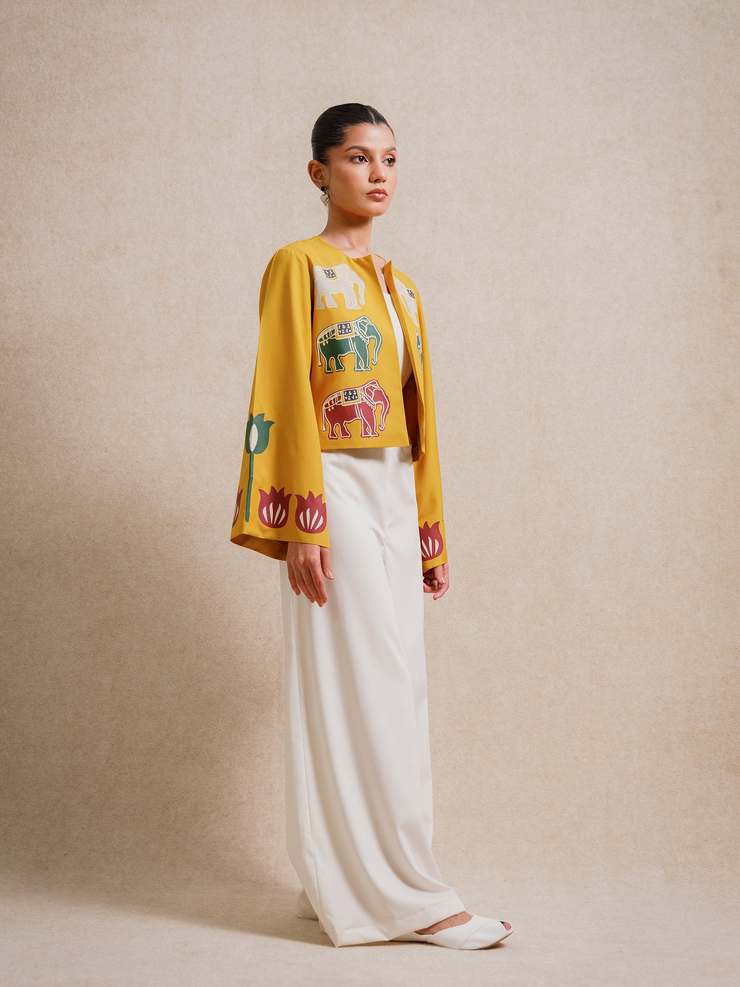 Front angled view of the Alam Guman Ochre short jacket featuring hand-printed elephant motifs on ochre fabric