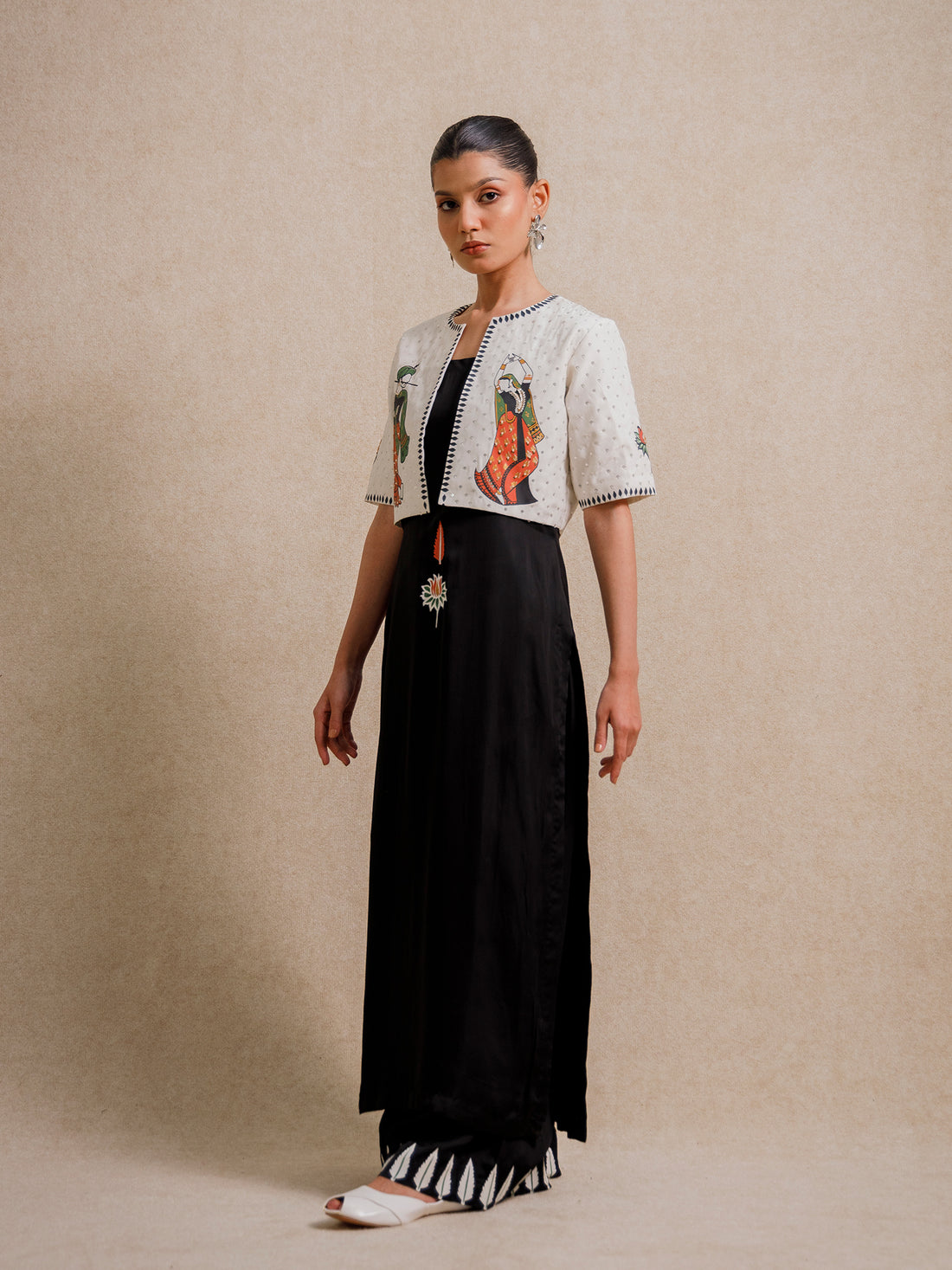 Front view of Eternal Lovers white three piece set featuring hand illustrated figures on a cropped jacket with flowing black skirt