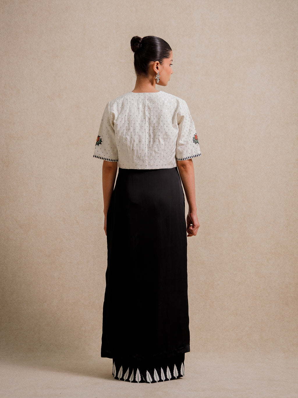 Back view of Eternal Lovers white three piece set featuring a textured cropped jacket paired with a flowing black skirt