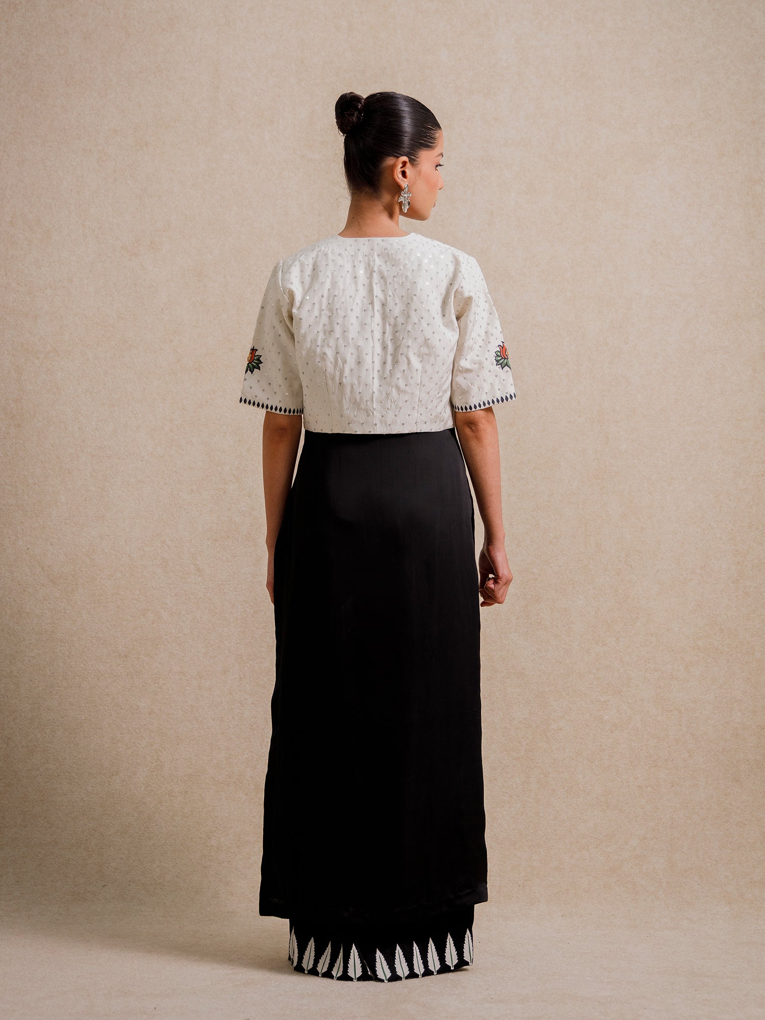 Back view of Eternal Lovers white three piece set featuring a textured cropped jacket paired with a flowing black skirt