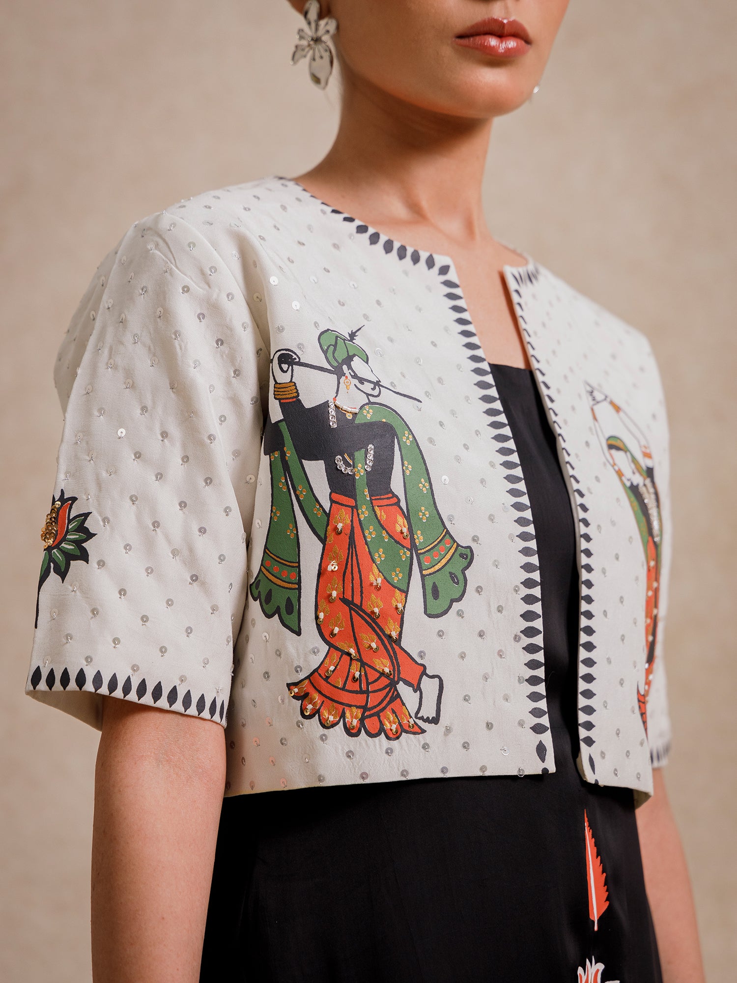 Close-up of Eternal Lovers white cropped jacket featuring hand-illustrated figures and textured embroidery details
