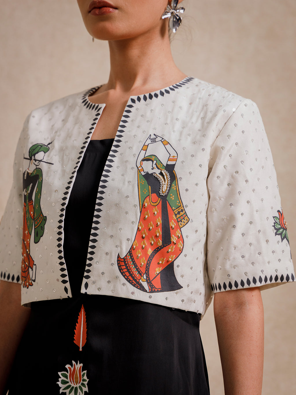 Close-up of Eternal Lovers white cropped jacket featuring hand-illustrated figures and textured embroidery details
