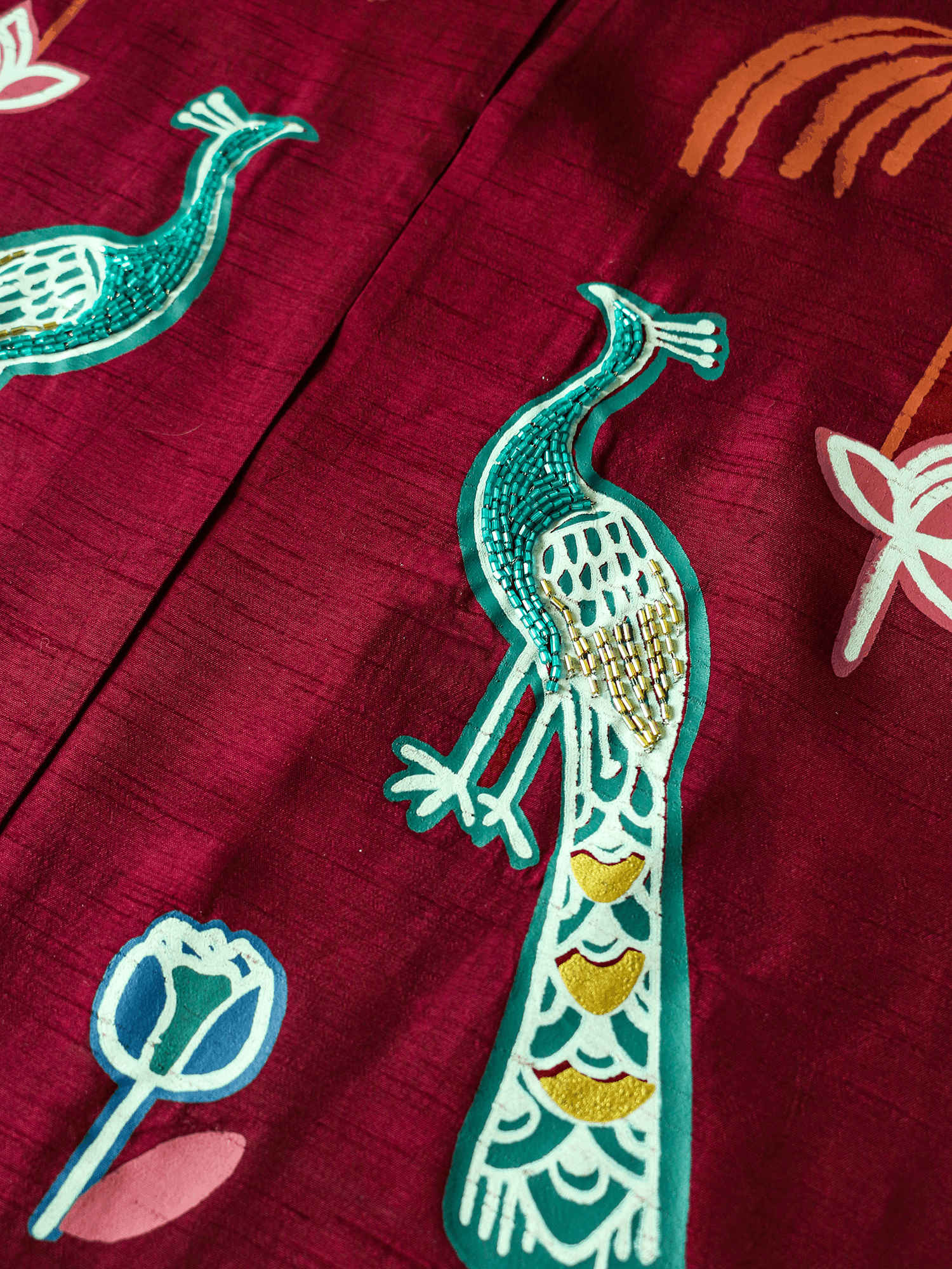 Close-up of hand-embroidered peacock motif on the front of the Forbidden Love Scarlet long jacket by Rangdasti