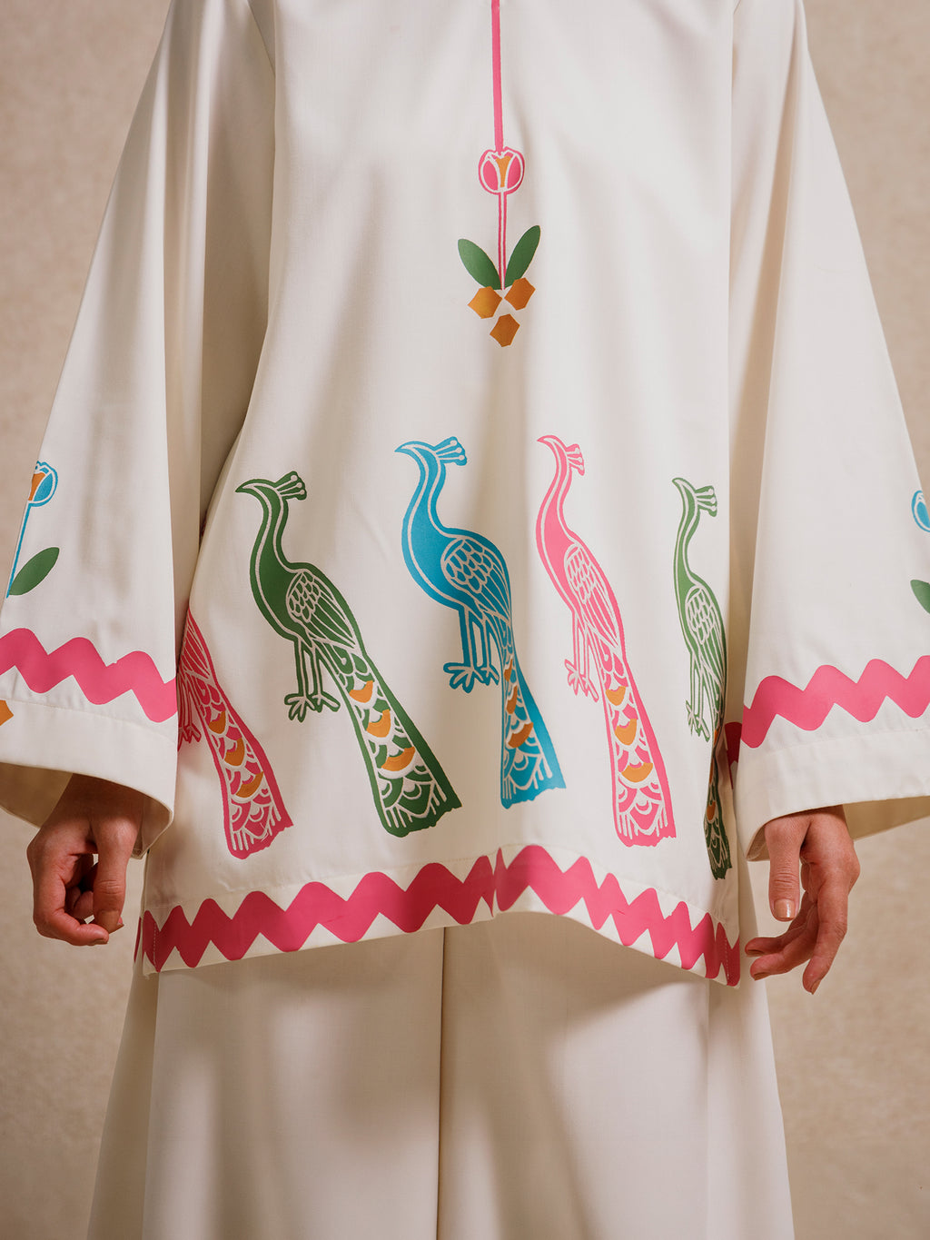 Detail of the Ivory Court two piece set highlighting hand-printed peacock motifs and scalloped hem detailing