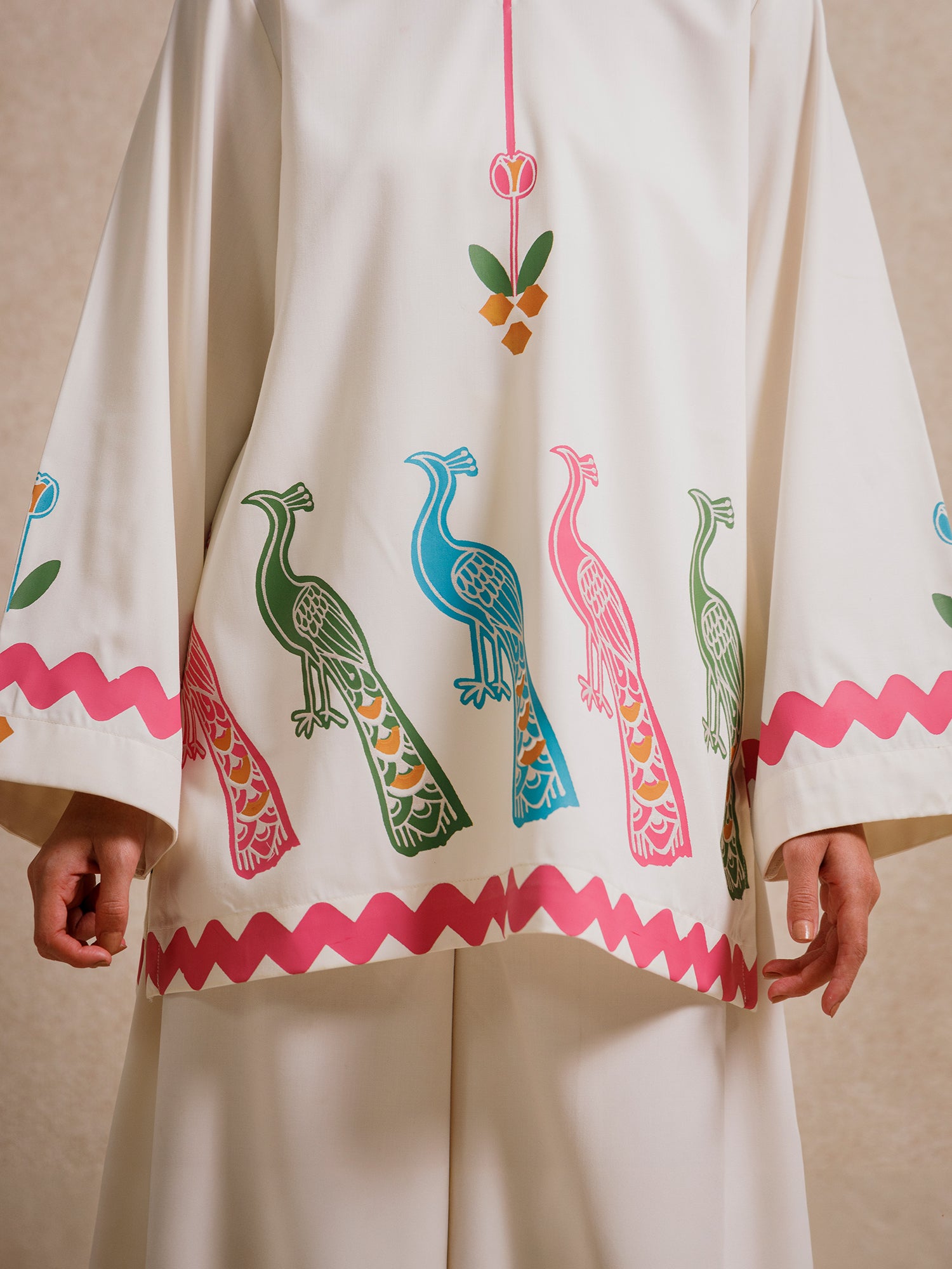 Detail of the Ivory Court two piece set highlighting hand-printed peacock motifs and scalloped hem detailing