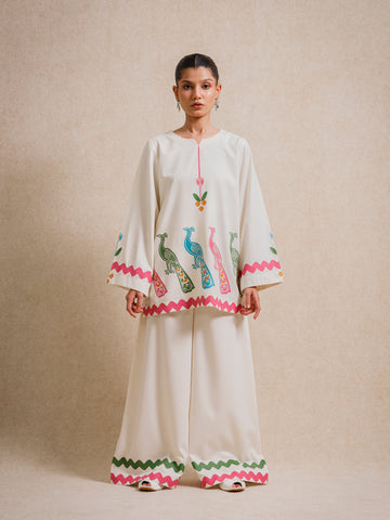 Ivory Court two piece set featuring hand-printed peacock motifs and scalloped detailing, styled against a neutral backdrop