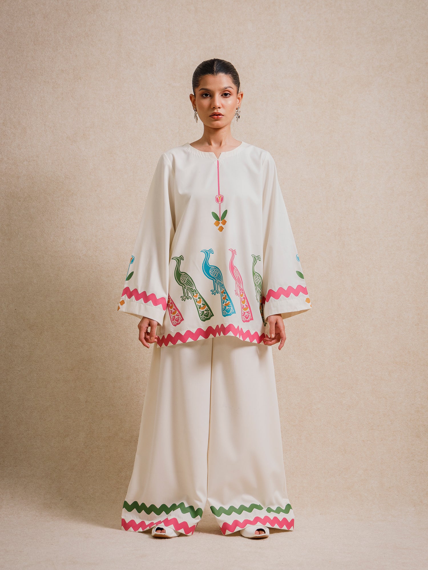 Ivory Court two piece set featuring hand-printed peacock motifs and scalloped detailing, styled against a neutral backdrop