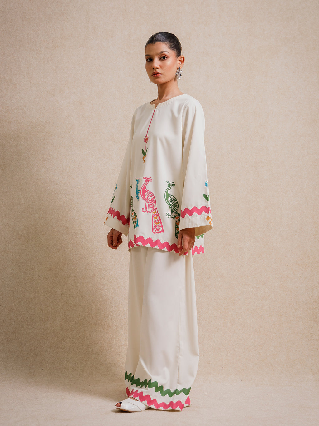 Ivory Court two piece set featuring hand-printed peacock motifs and scalloped detailing, styled against a neutral backdrop