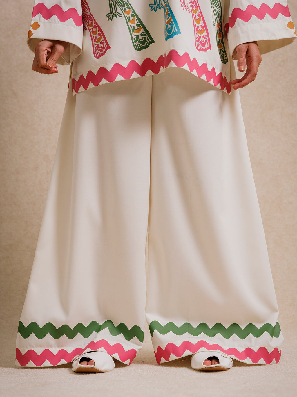 Close-up of Ivory Court two piece set trousers with scalloped hem detailing in pink and green