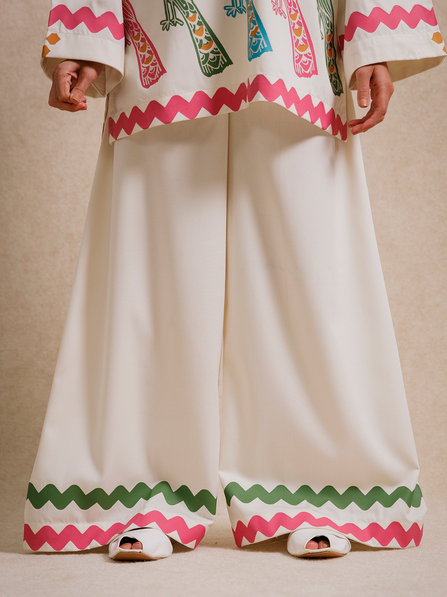 Close-up of Ivory Court two piece set trousers with scalloped hem detailing in pink and green